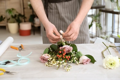 Male florist creating bouquet at workplace