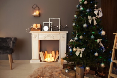 Photo of Stylish room interior with Christmas tree and decorative fireplace