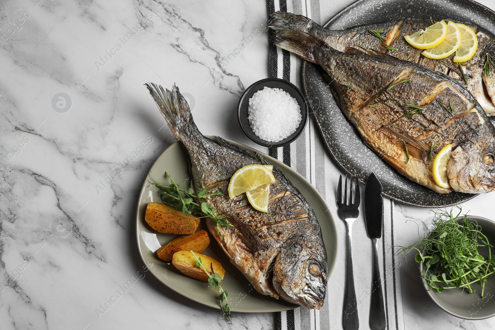 Photo of Seafood. Delicious baked fish served on white marble table, flat lay with space for text