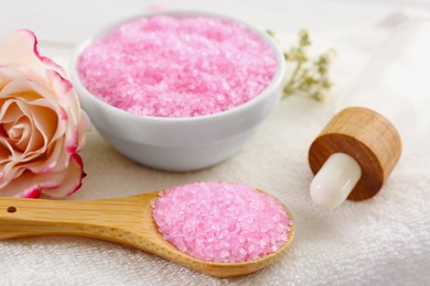 Aromatic sea salt and beautiful flower on towel, closeup