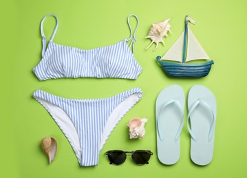 Flat lay composition with beach objects on green background