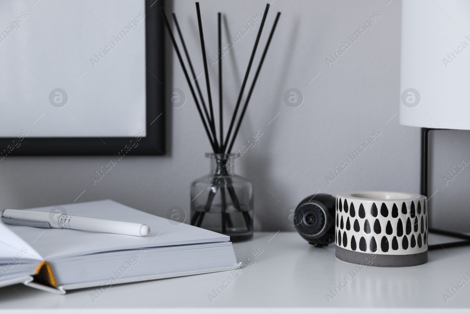 Photo of Small camera hidden among home stuff on white table indoors