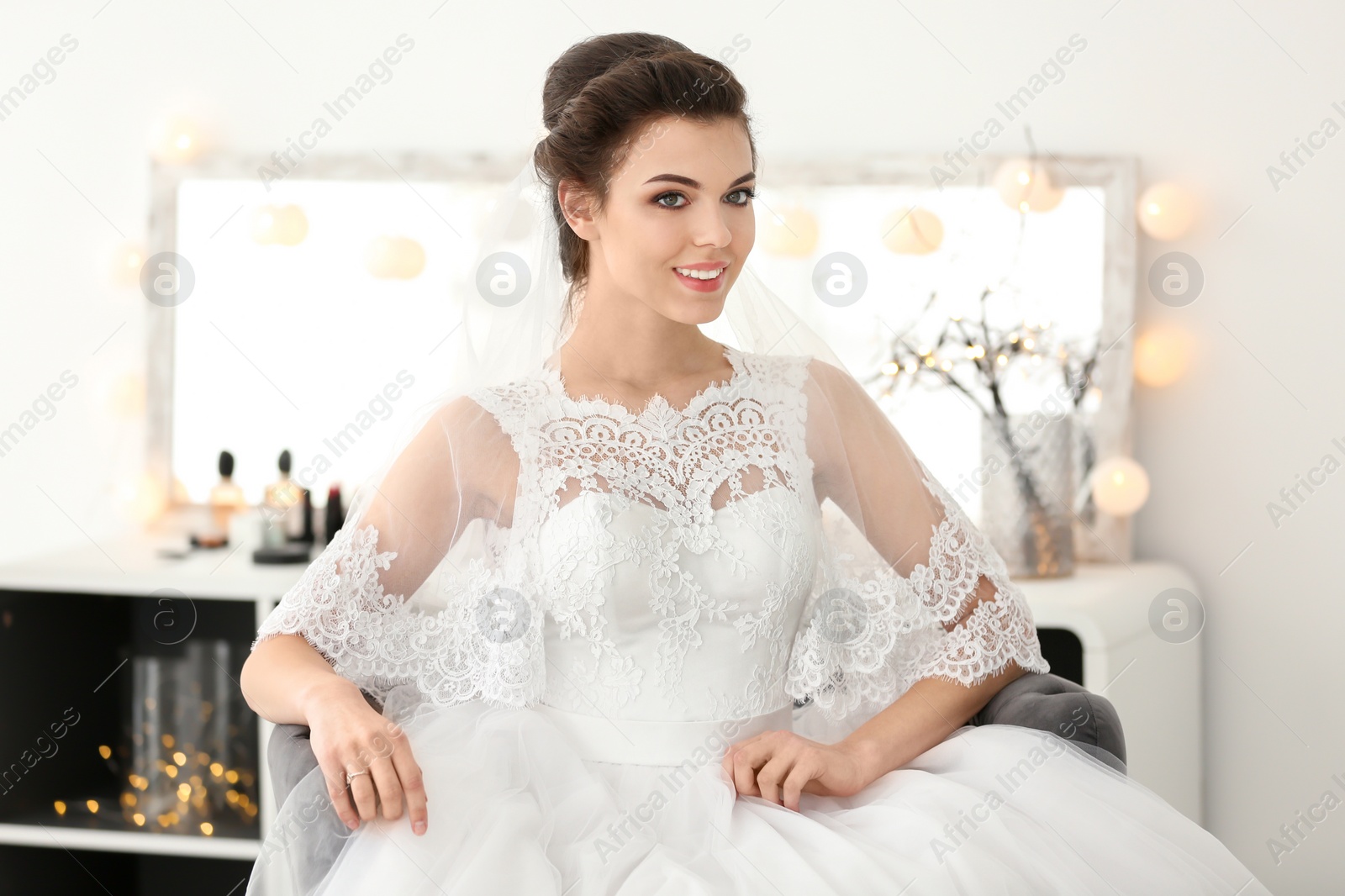 Photo of Beautiful young bride with makeup created by professional artist indoors