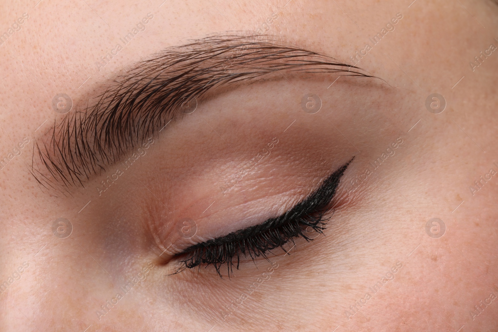 Photo of Makeup product. Woman with black eyeliner and beautiful eyebrow, closeup