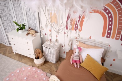 Photo of Stylish room with comfortable bed for kids, above view. Interior design