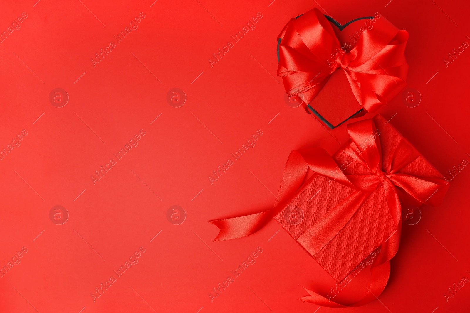 Photo of Beautiful gift boxes with bows on red background, flat lay. Space for text