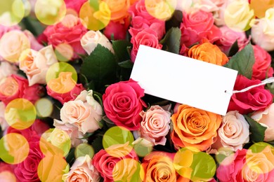 Photo of Bouquet of beautiful roses with blank card, top view