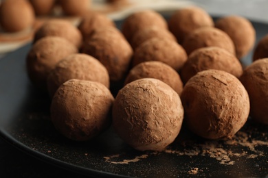 Photo of Plate with tasty chocolate truffles, closeup view