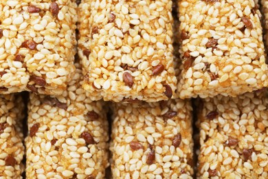 Photo of Tasty sesame seed bars as background, closeup