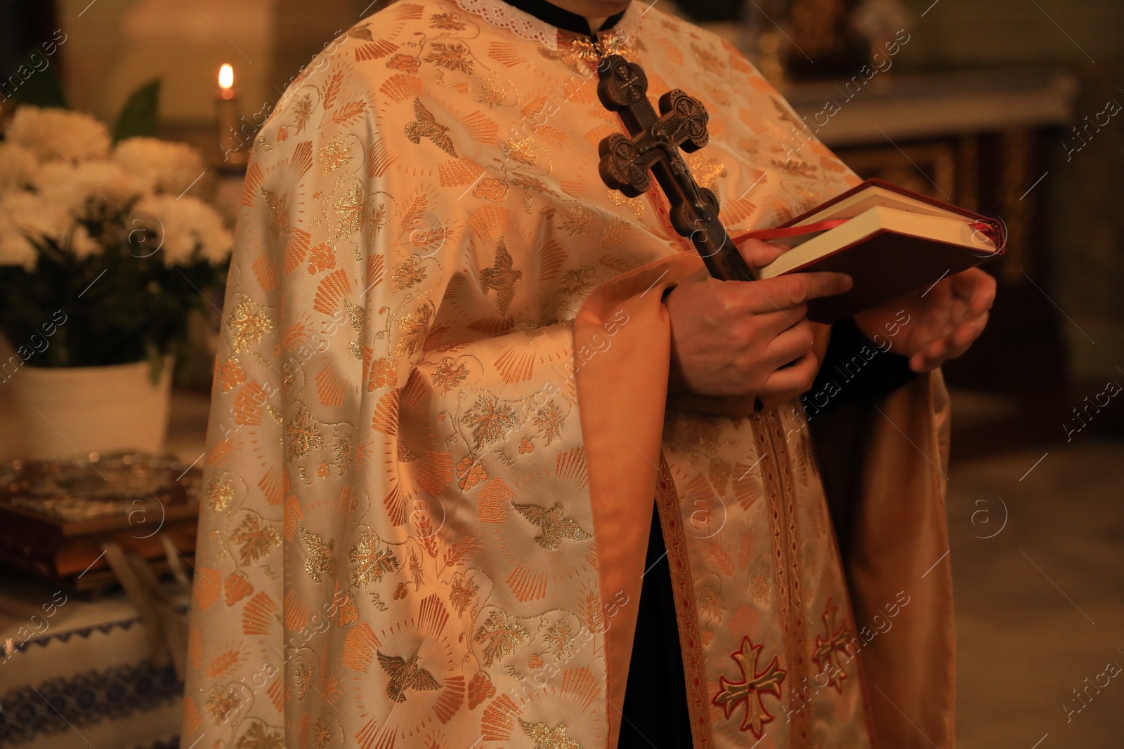 Photo of Stryi, Ukraine - September 11, 2022: Priest conducting baptism ceremony near altar in Assumption of Blessed Virgin Mary cathedral, closeup