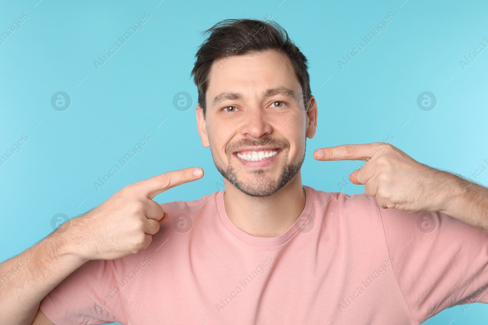 Photo of Smiling man with perfect teeth on color background