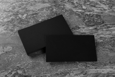 Photo of Blank black business cards on grey background, above view. Mockup for design