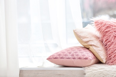 Photo of Different soft pillows on windowsill