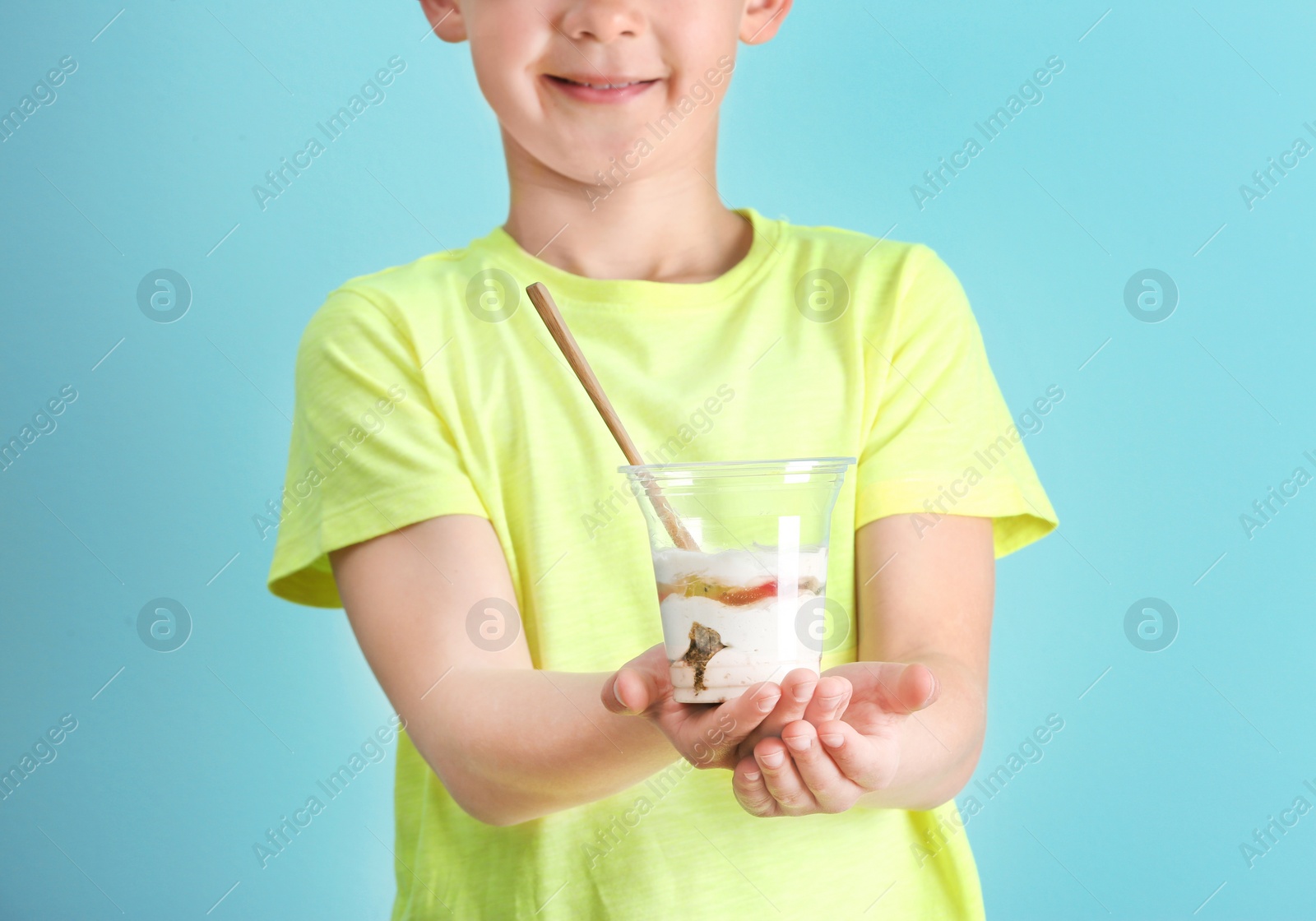 Photo of Little boy with yogurt on color background