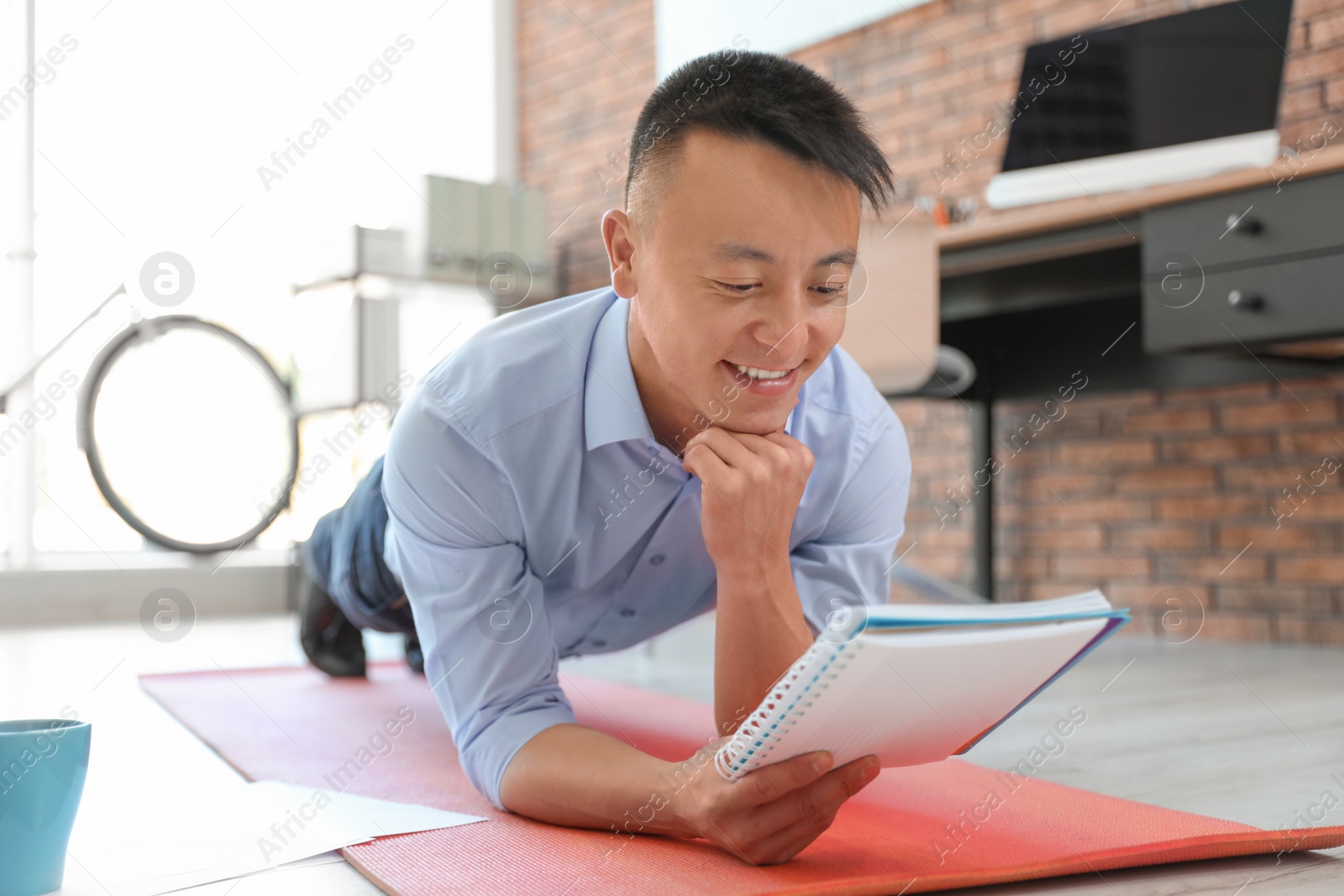 Photo of Young businessman doing exercises in office. Workplace fitness