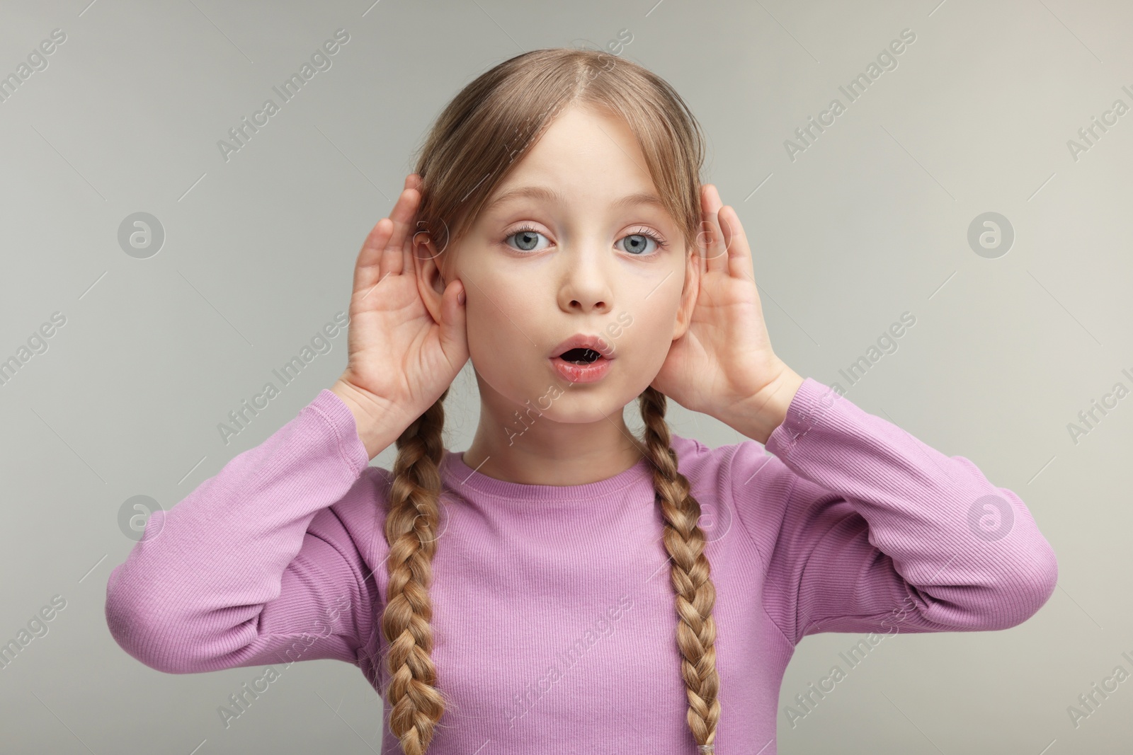 Photo of Little girl with hearing problem on grey background