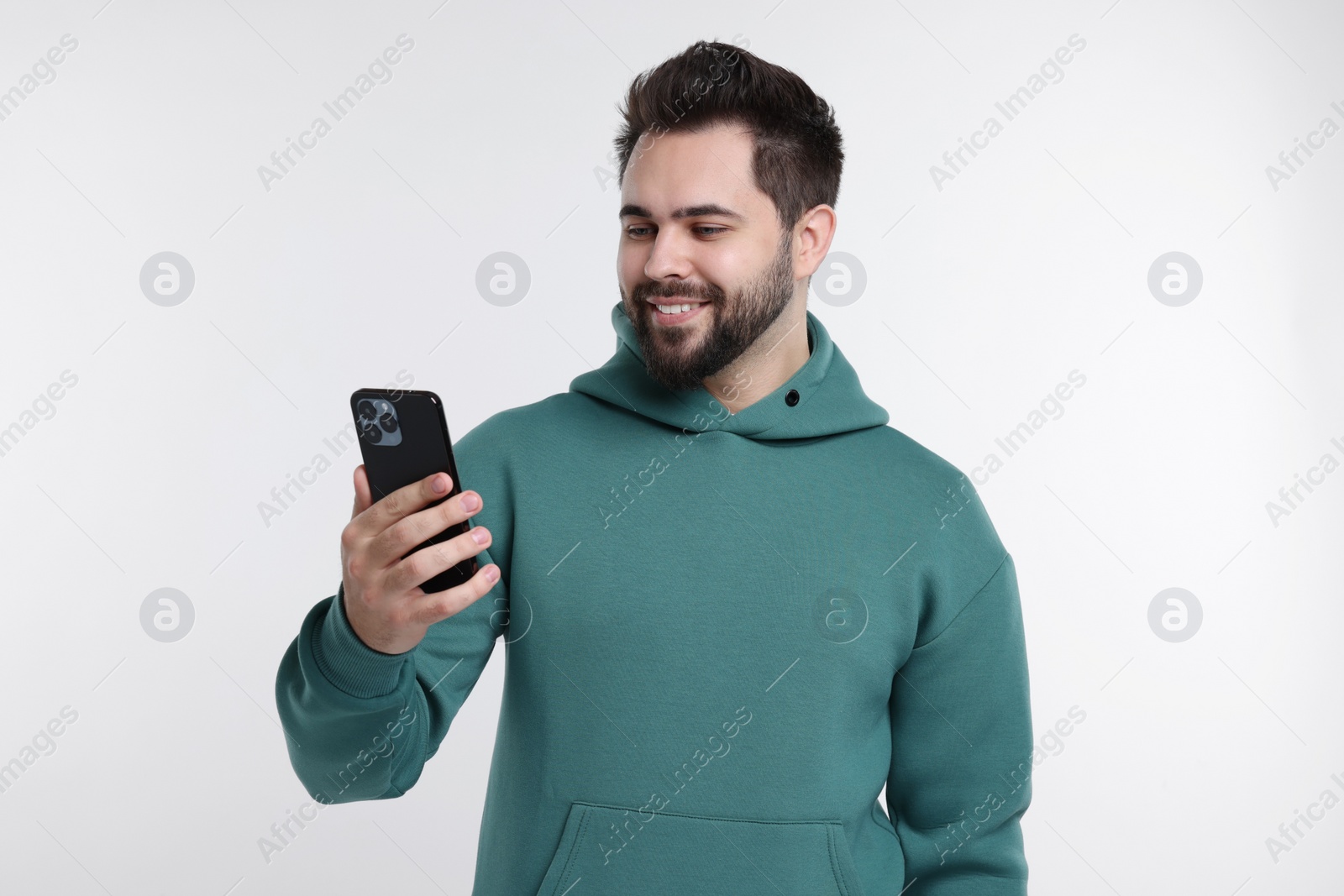 Photo of Happy young man using smartphone on white background