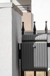 Dark metal letter box on fence outdoors