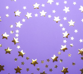 Frame made of confetti stars with space for text on violet background, top view. Christmas celebration