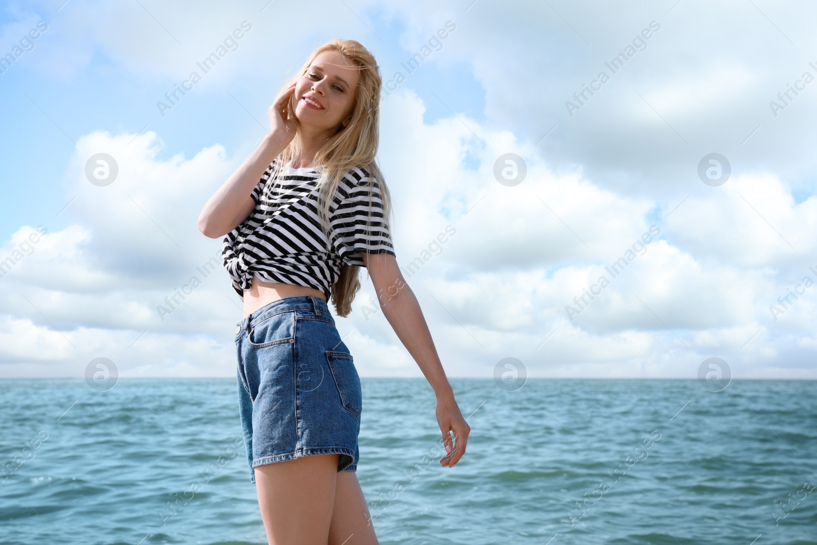 Photo of Beautiful young woman near sea on sunny day in summer