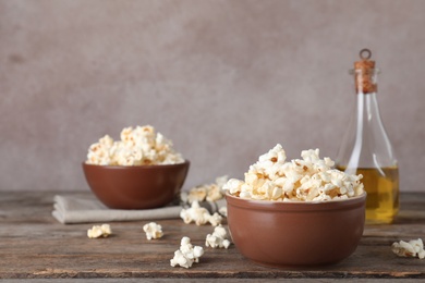 Bowl with tasty popcorn on wooden table. Space for text