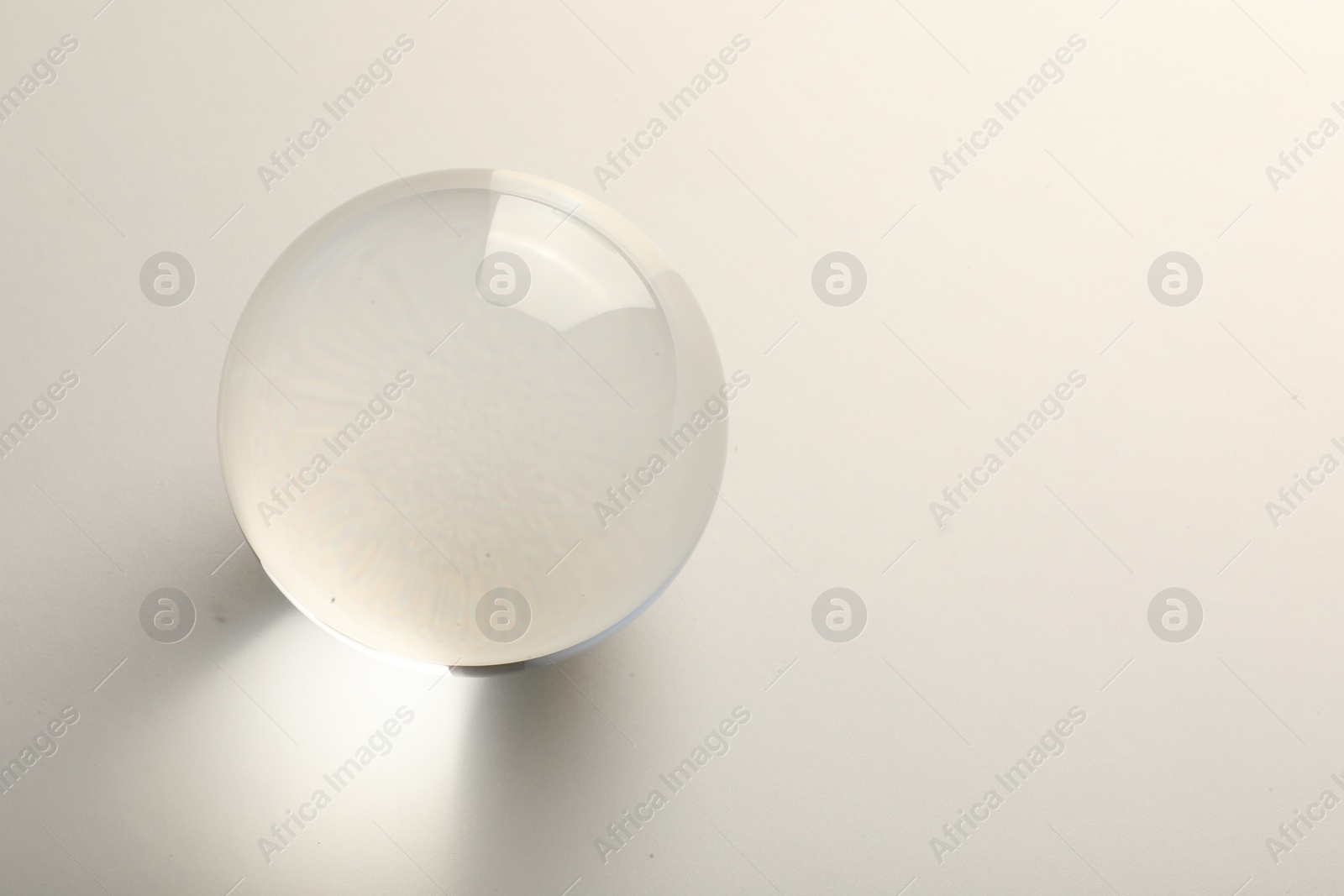 Photo of Transparent glass ball on white background. Space for text