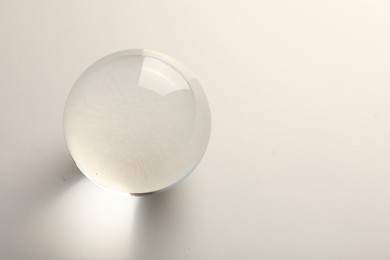 Photo of Transparent glass ball on white background. Space for text