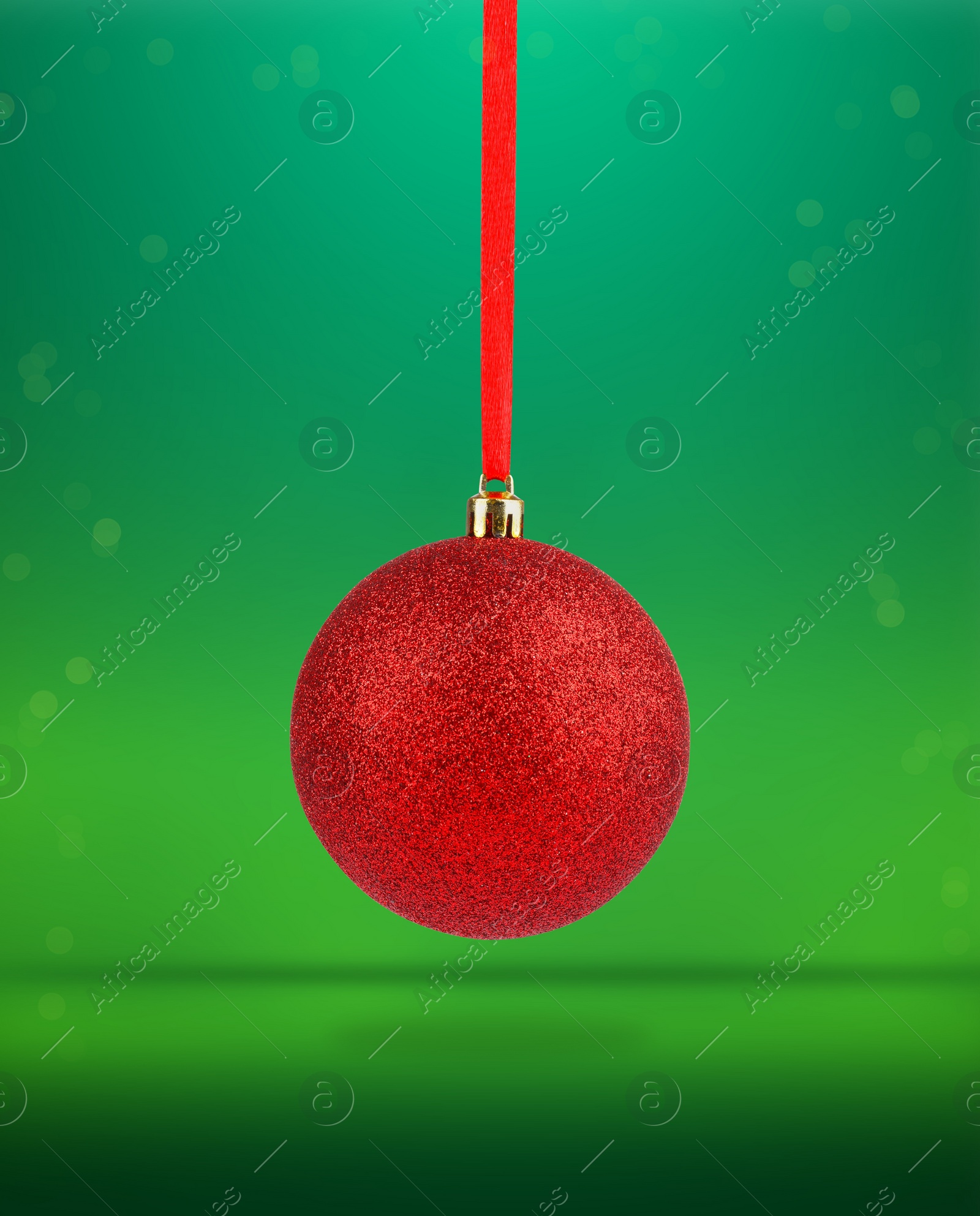 Image of Beautiful red Christmas ball hanging on green background