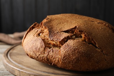 Photo of Freshly baked sourdough bread on wooden table, closeup