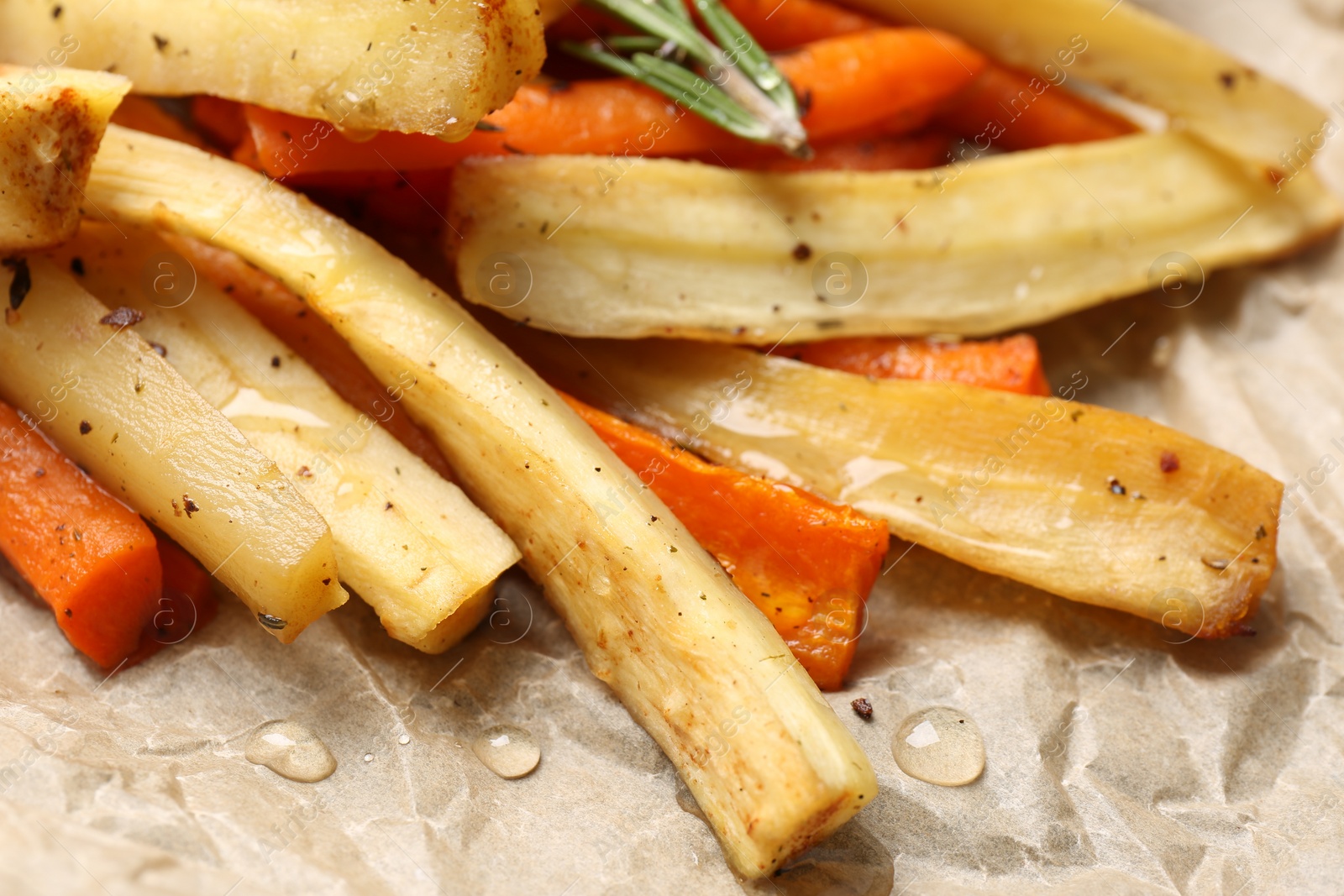 Photo of Tasty baked parsnip and bell pepper on parchment, closeup