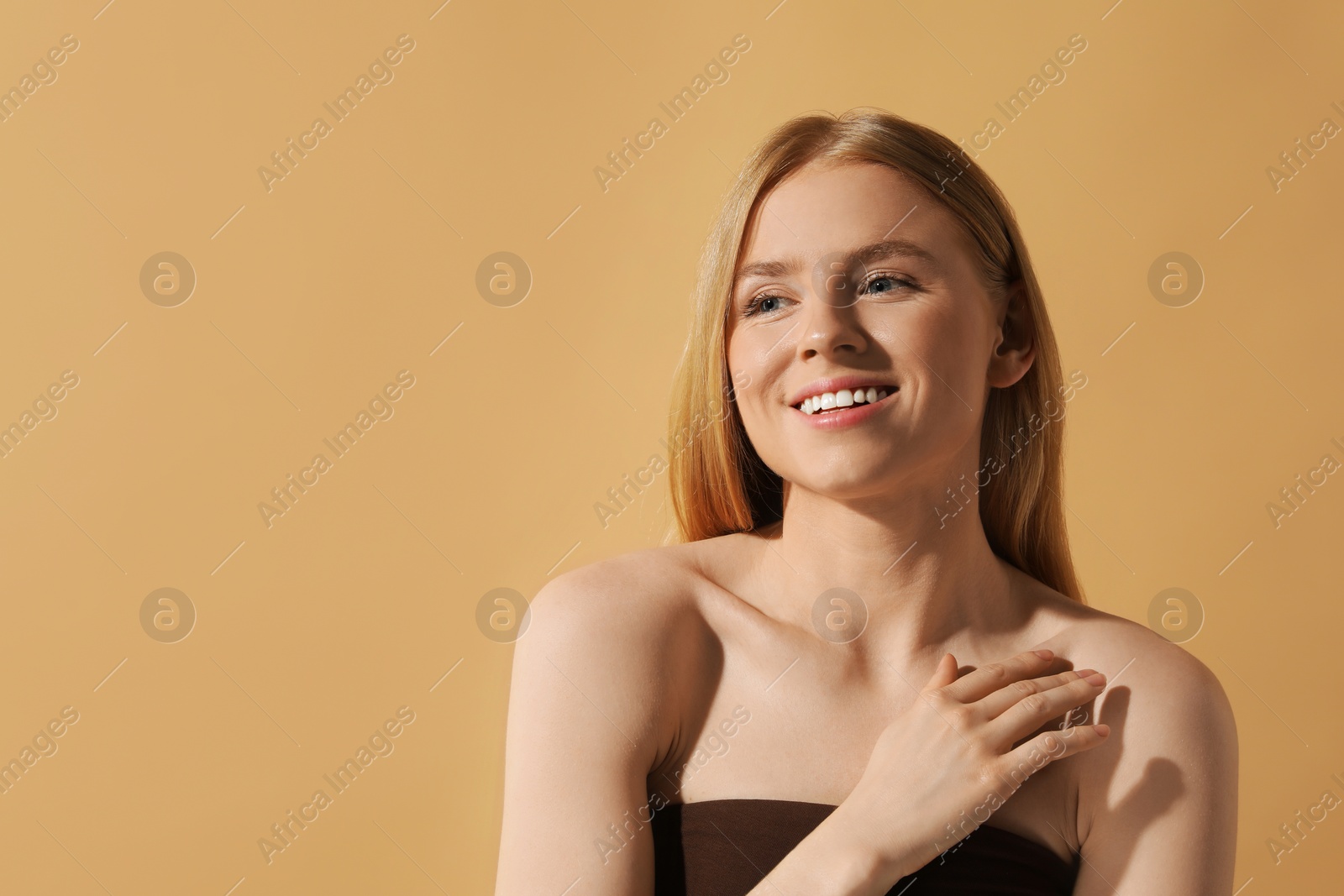 Photo of Beautiful young woman posing on beige background, space for text