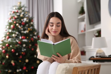 Photo of Christmas mood. Woman reading book in cosy room