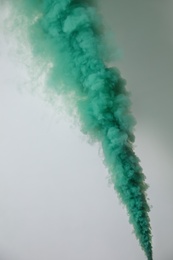 Photo of Bright green smoke bomb on white background