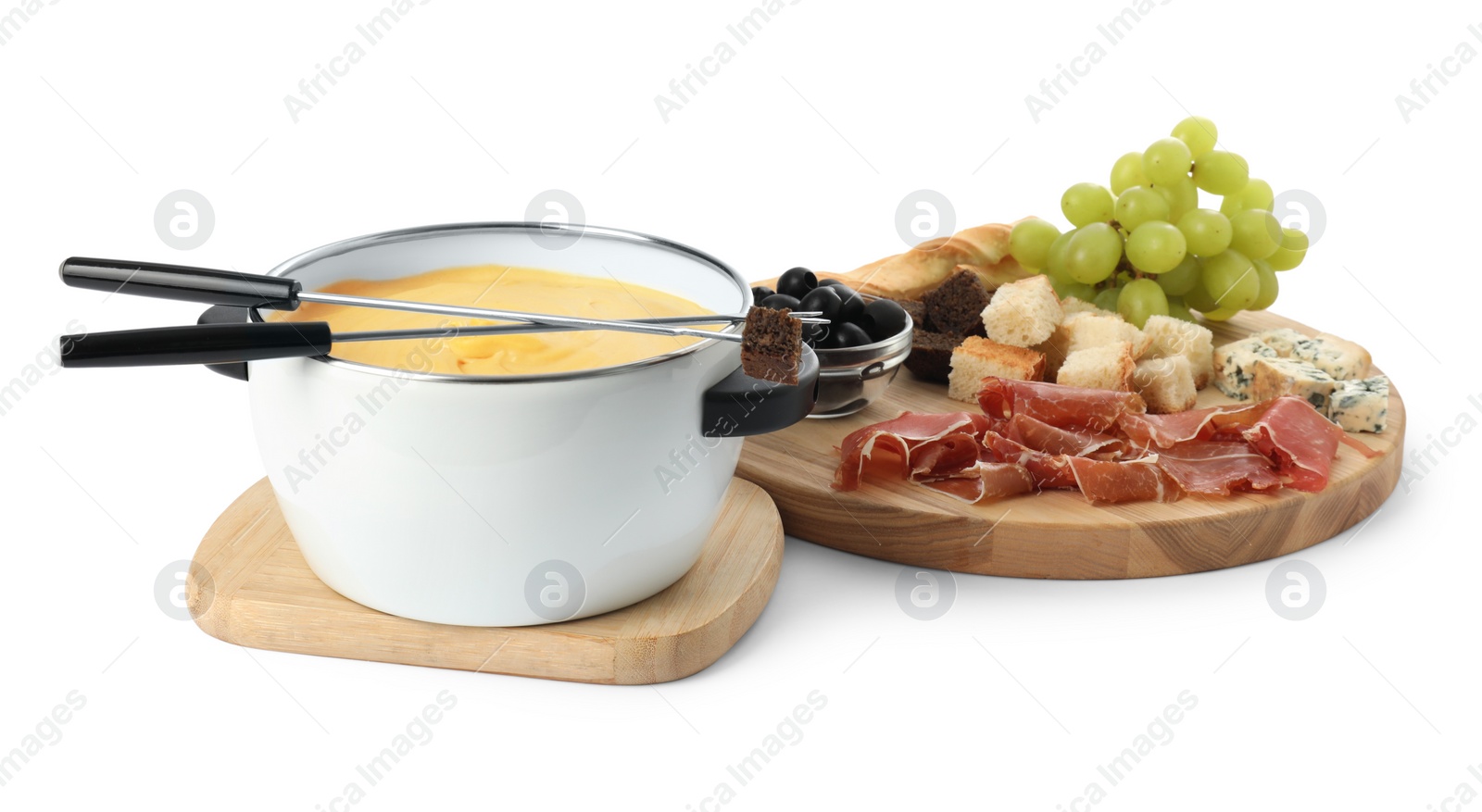 Photo of Fondue with tasty melted cheese, forks and different snacks isolated on white