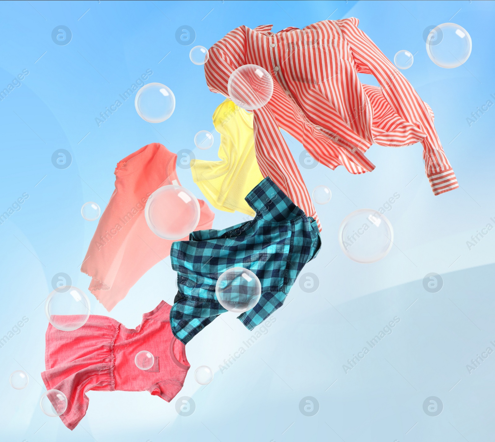 Image of Washing powder bubbles and clothes flying in cloudy sky