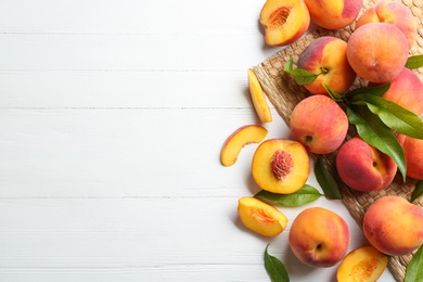 Photo of Fresh sweet peaches on white wooden table, flat lay. Space for text