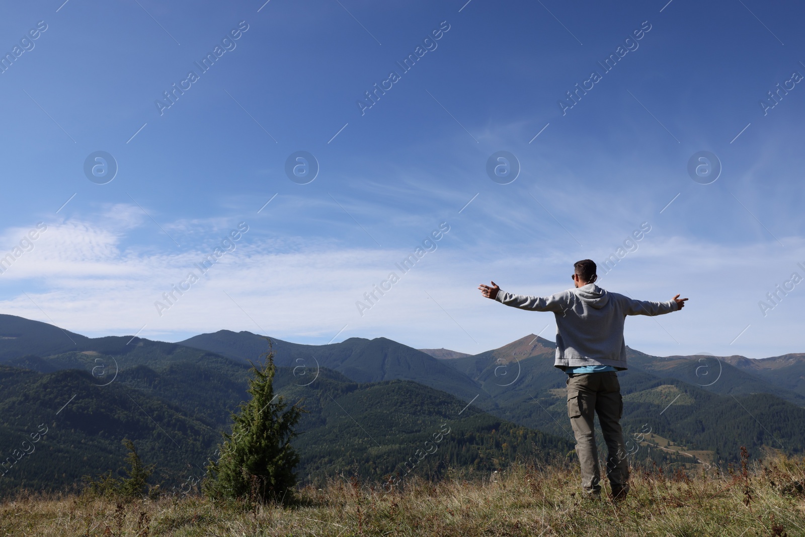 Photo of Man enjoying picturesque view of mountain landscape on sunny day