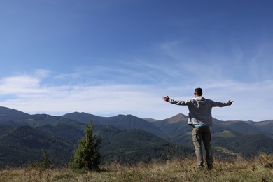 Man enjoying picturesque view of mountain landscape on sunny day