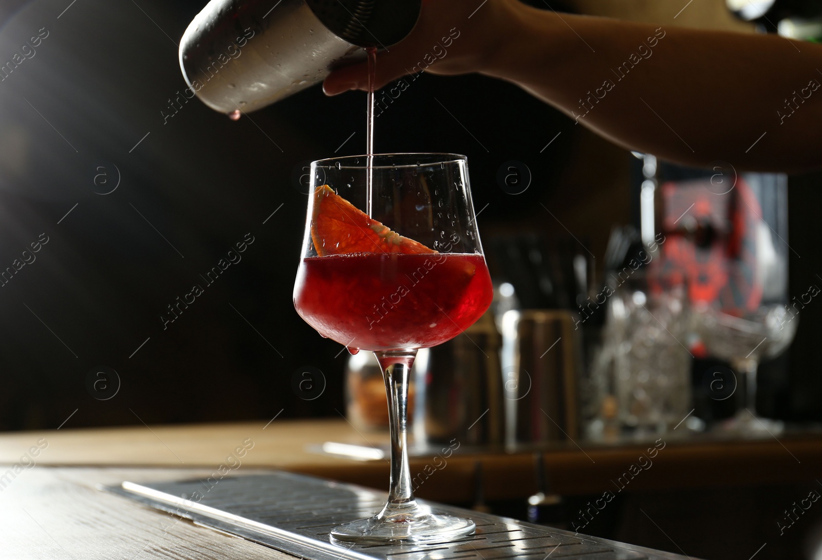 Photo of Bartender preparing fresh alcoholic cocktail at bar counter, closeup