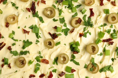 Photo of Fresh natural butter with cut olives, parsley and sun-dried tomatoes as background, top view