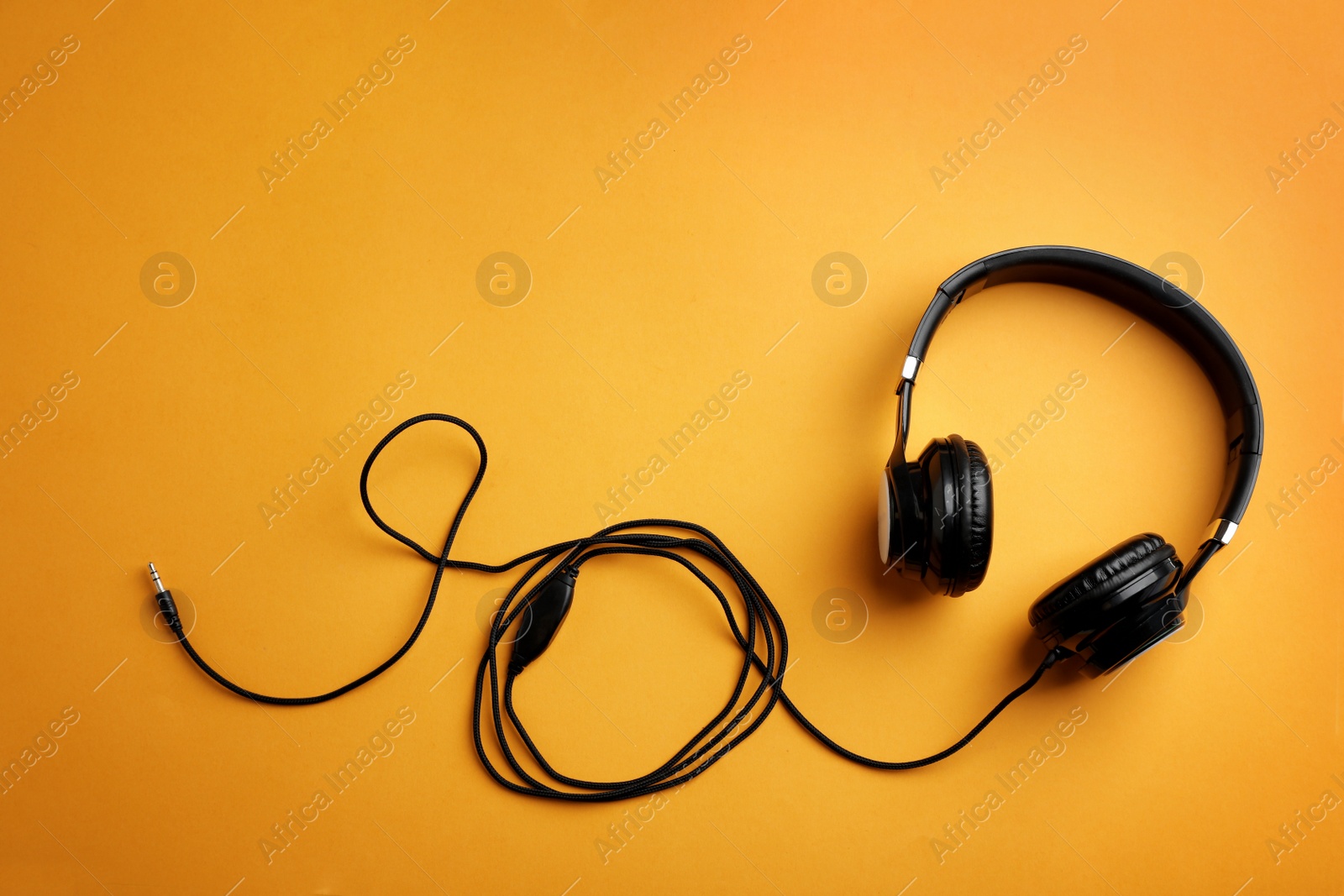 Photo of Stylish headphones on color background, top view. Space for text