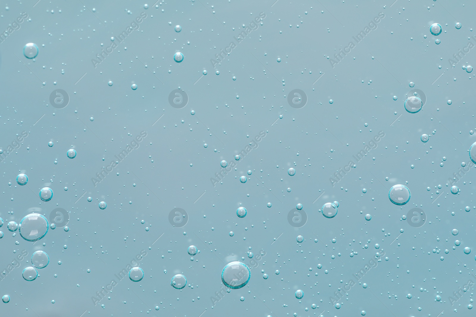 Photo of Transparent cleansing gel on dusty light blue background, top view. Cosmetic product