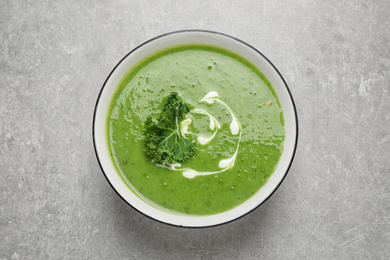 Tasty kale soup on grey table, top view