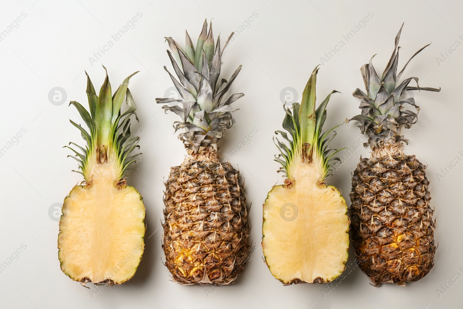 Photo of Fresh pineapples on light background, flat lay