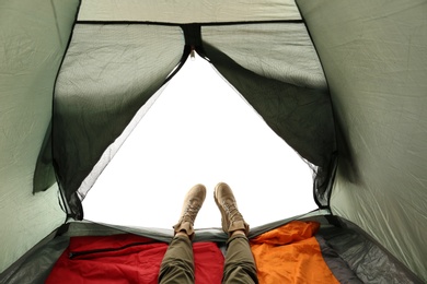 Photo of Closeup of female in camping tent on white background, view from inside