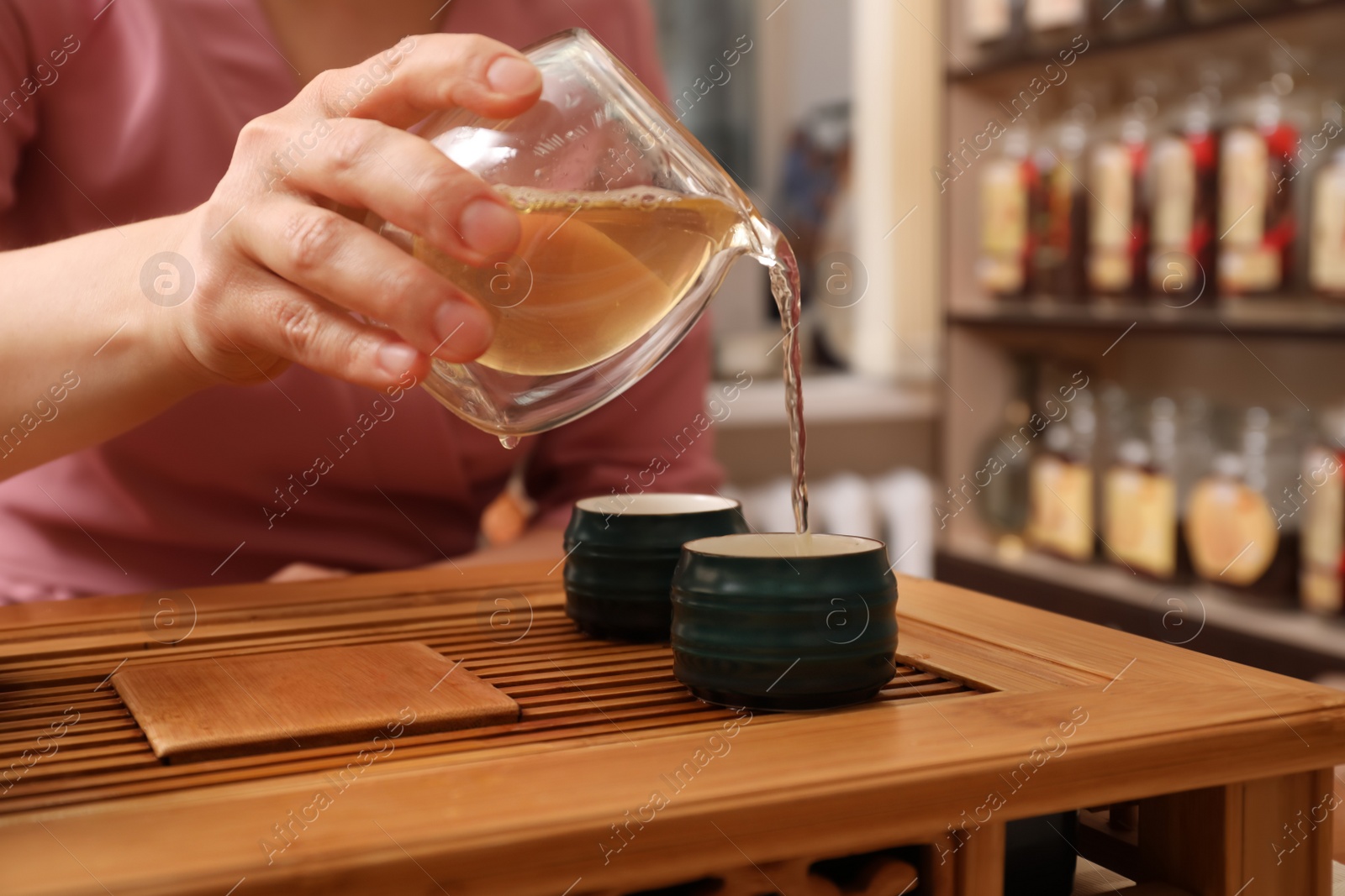 Photo of Master conducting traditional tea ceremony at table, closeup