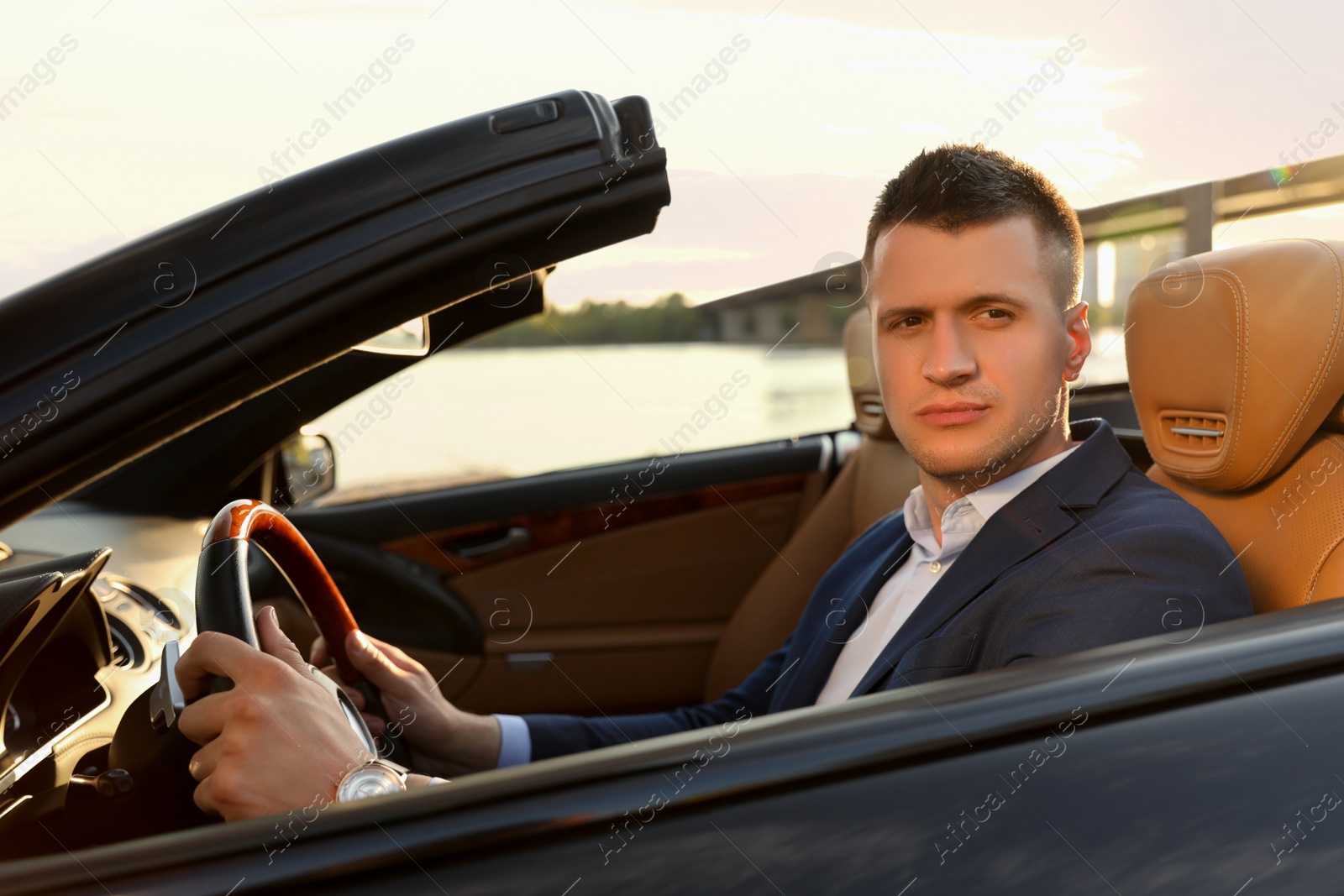 Photo of Young businessman in luxury convertible car outdoors