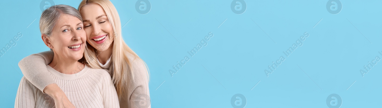 Image of Happy mother and daughter on light blue background, space for text. Banner design