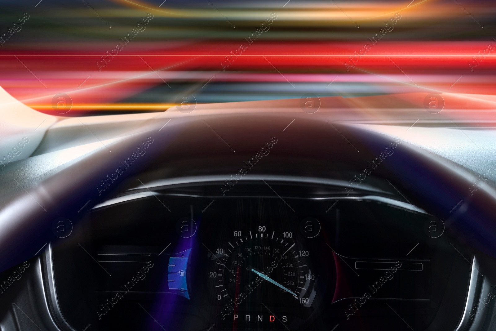 Image of Speedometer behind steering wheel in car, motion blur effect