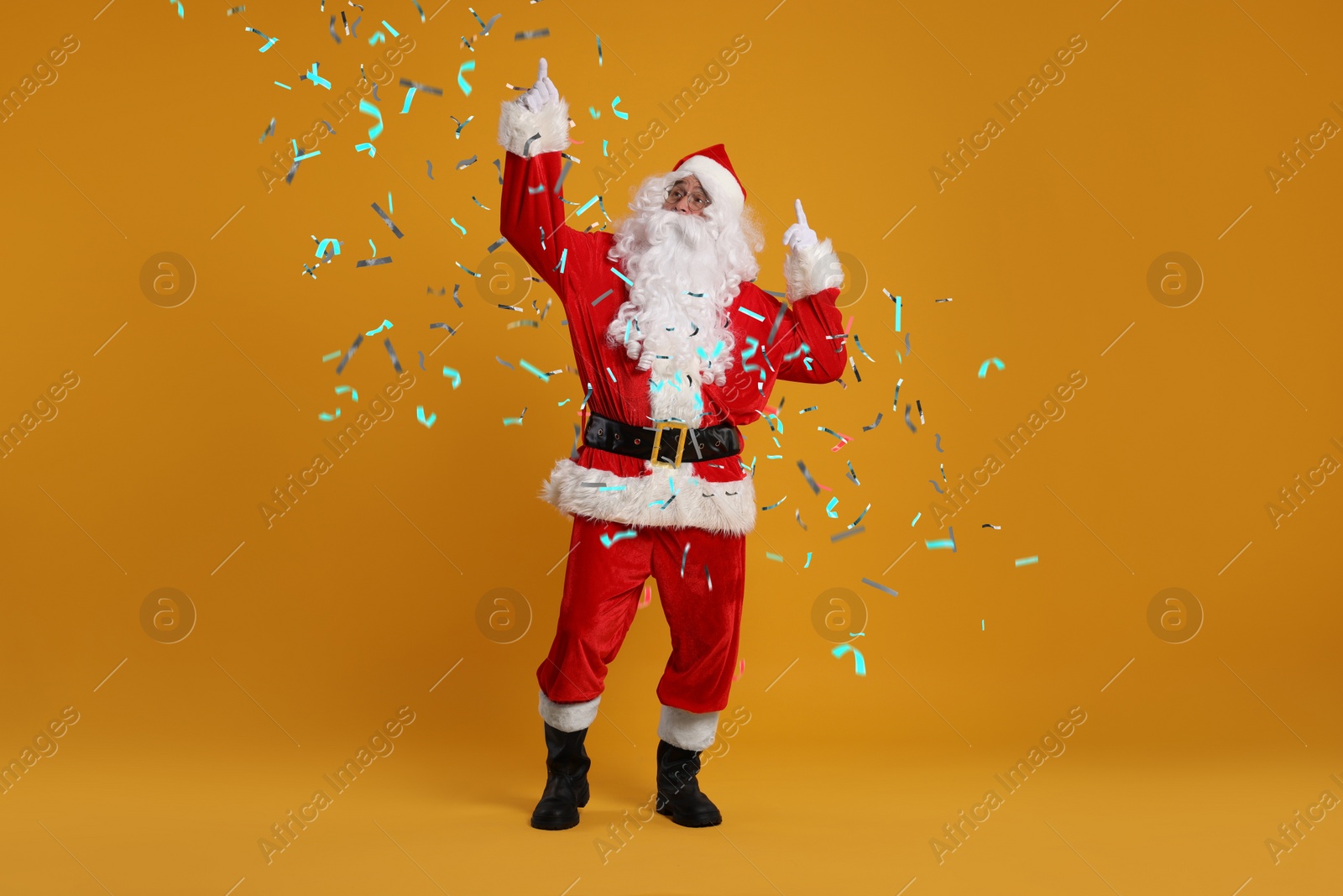 Image of Santa Claus under falling confetti on orange background